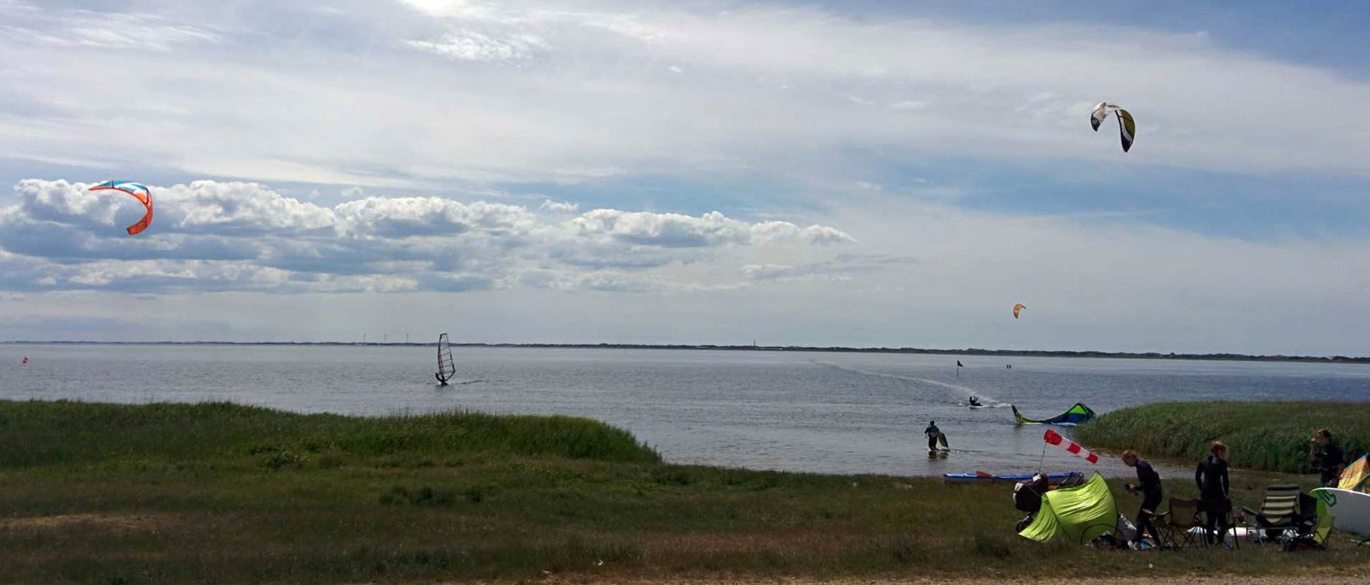 Blick auf das Meer mit Kitesurfern am Strand und im Wasser